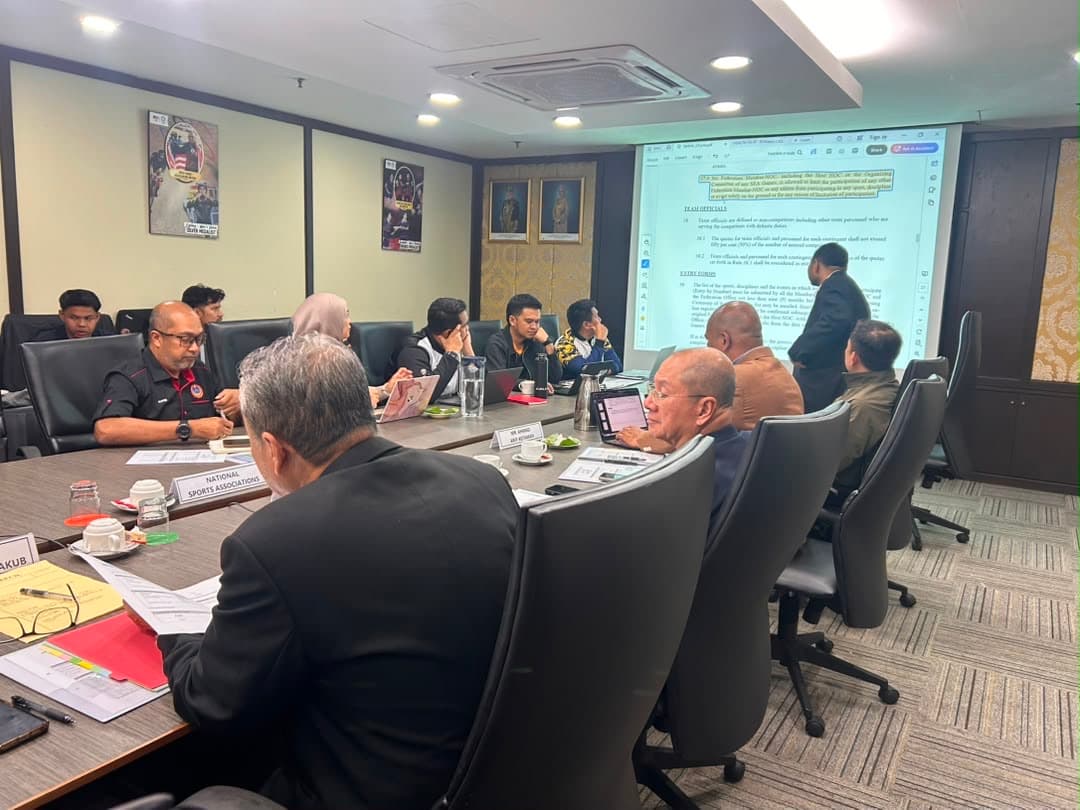 Officials reviewing technical rules, including team officials and entry forms, at the meeting.